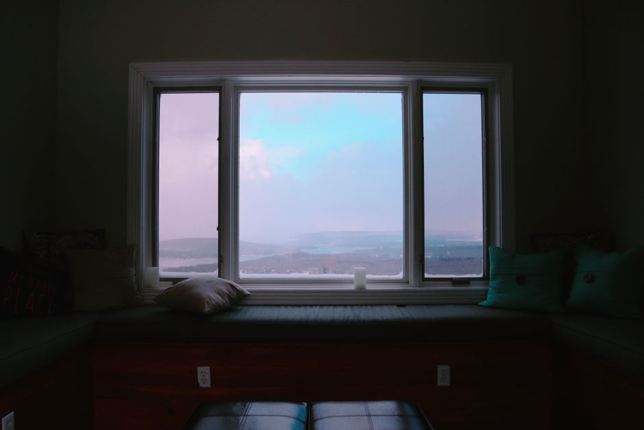 Tranquil view from a window seat with a calming outdoor vista, featuring soft cushions and a peaceful atmosphere.